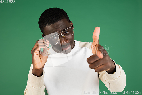 Image of African man\'s portrait isolated on green studio background with copyspace