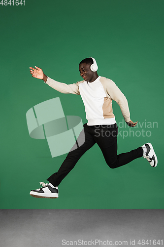 Image of African man\'s portrait isolated on green studio background with copyspace