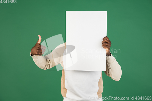 Image of African man\'s portrait isolated on green studio background with copyspace