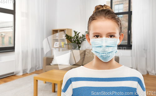 Image of teenage girl in protective medical mask at home