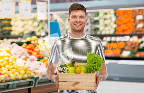 Image of happy smiling man with food in wooden box