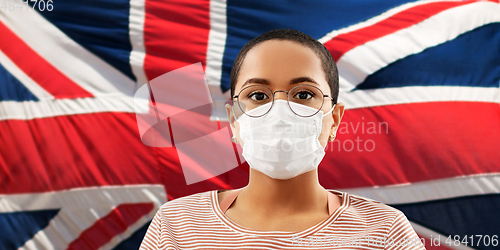 Image of african woman in mask over flag of united kingdom