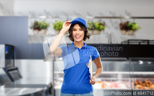 Image of happy smiling delivery girl with clipboard at shop