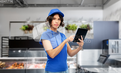 Image of delivery girl in uniform with tablet pc at store