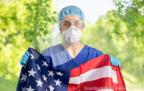 Image of doctor in goggles and mask holding flag of america