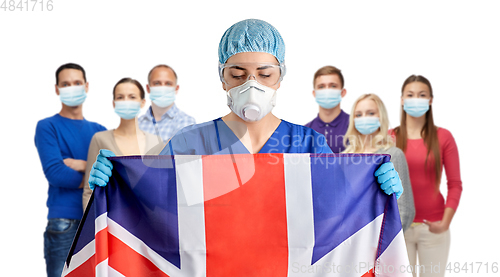 Image of doctor in goggles and mask holding flag of england