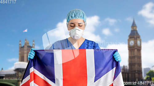 Image of doctor in goggles and mask holding flag of england