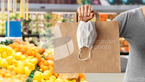 Image of woman with shopping bag and mask at grocery