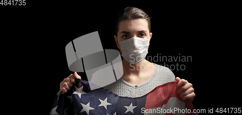 Image of sick woman in face mask holding flag of america