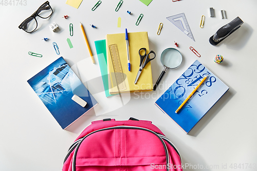 Image of pink backpack with books and school supplies