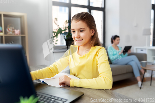 Image of student girl with laptop learning online at home