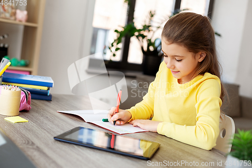 Image of student girl writing to notebook at home