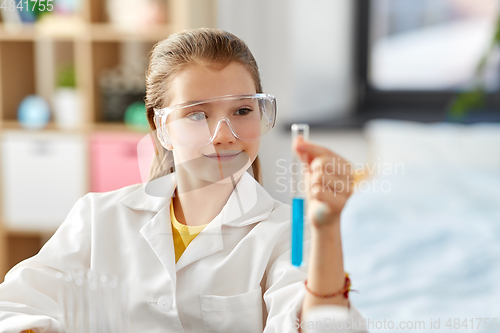 Image of girl with test tube studying chemistry at home