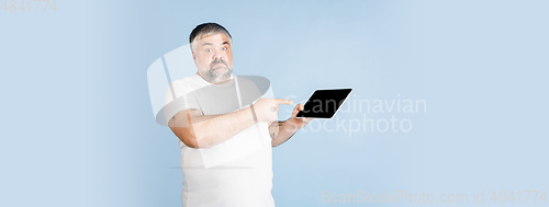 Image of Handsome caucasian plus size male model isolated on blue studio background. Concept of inclusion, human emotions, facial expression