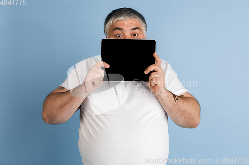 Image of Handsome caucasian plus size male model isolated on blue studio background. Concept of inclusion, human emotions, facial expression