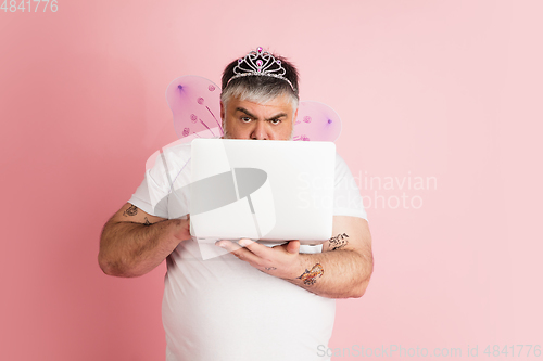 Image of Handsome caucasian plus size male model isolated on coral pink studio background. Concept of inclusion, human emotions, facial expression