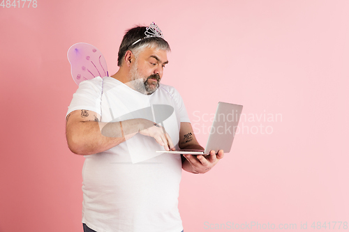 Image of Handsome caucasian plus size male model isolated on coral pink studio background. Concept of inclusion, human emotions, facial expression