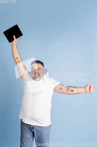 Image of Handsome caucasian plus size male model isolated on blue studio background. Concept of inclusion, human emotions, facial expression