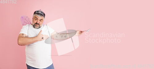 Image of Handsome caucasian plus size male model isolated on coral pink studio background. Concept of inclusion, human emotions, facial expression