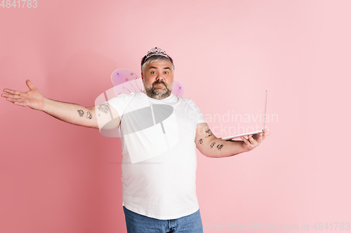 Image of Handsome caucasian plus size male model isolated on coral pink studio background. Concept of inclusion, human emotions, facial expression