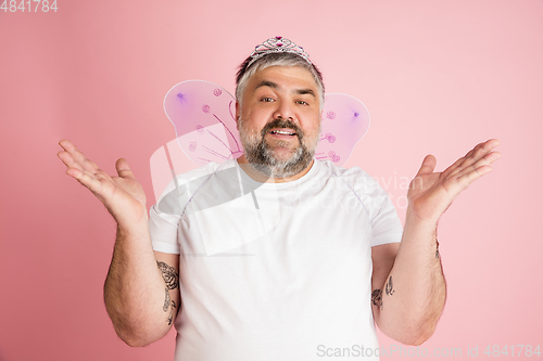 Image of Handsome caucasian plus size male model isolated on coral pink studio background. Concept of inclusion, human emotions, facial expression