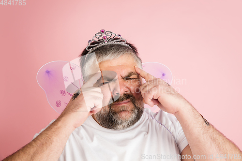 Image of Handsome caucasian plus size male model isolated on coral pink studio background. Concept of inclusion, human emotions, facial expression