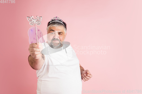 Image of Handsome caucasian plus size male model isolated on coral pink studio background. Concept of inclusion, human emotions, facial expression