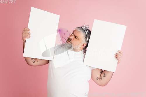 Image of Handsome caucasian plus size male model isolated on coral pink studio background. Concept of inclusion, human emotions, facial expression