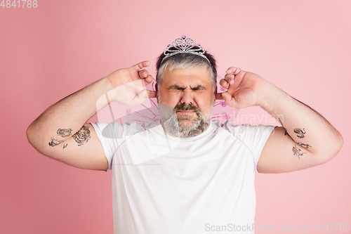 Image of Handsome caucasian plus size male model isolated on coral pink studio background. Concept of inclusion, human emotions, facial expression