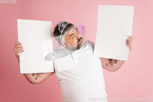 Image of Handsome caucasian plus size male model isolated on coral pink studio background. Concept of inclusion, human emotions, facial expression