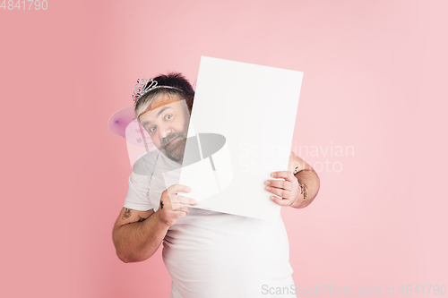 Image of Handsome caucasian plus size male model isolated on coral pink studio background. Concept of inclusion, human emotions, facial expression