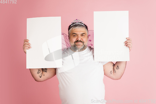 Image of Handsome caucasian plus size male model isolated on coral pink studio background. Concept of inclusion, human emotions, facial expression