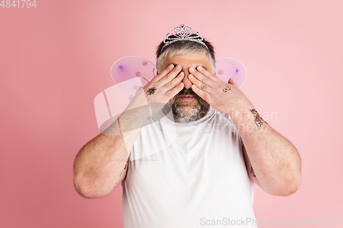 Image of Handsome caucasian plus size male model isolated on coral pink studio background. Concept of inclusion, human emotions, facial expression