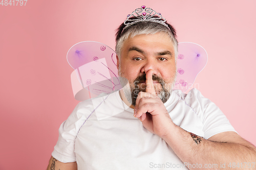 Image of Handsome caucasian plus size male model isolated on coral pink studio background. Concept of inclusion, human emotions, facial expression