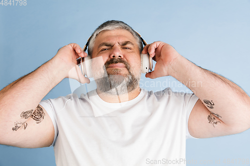 Image of Handsome caucasian plus size male model isolated on blue studio background. Concept of inclusion, human emotions, facial expression