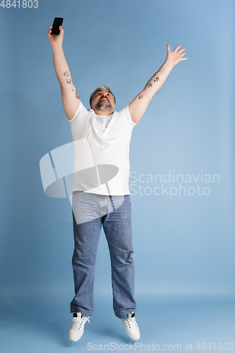 Image of Handsome caucasian plus size male model isolated on blue studio background. Concept of inclusion, human emotions, facial expression