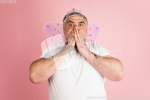 Image of Handsome caucasian plus size male model isolated on coral pink studio background. Concept of inclusion, human emotions, facial expression