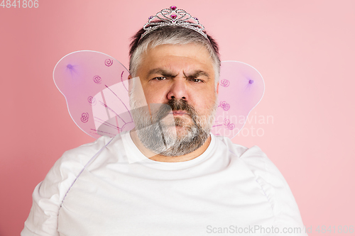 Image of Handsome caucasian plus size male model isolated on coral pink studio background. Concept of inclusion, human emotions, facial expression