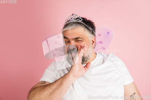 Image of Handsome caucasian plus size male model isolated on coral pink studio background. Concept of inclusion, human emotions, facial expression