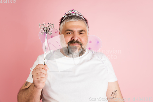 Image of Handsome caucasian plus size male model isolated on coral pink studio background. Concept of inclusion, human emotions, facial expression