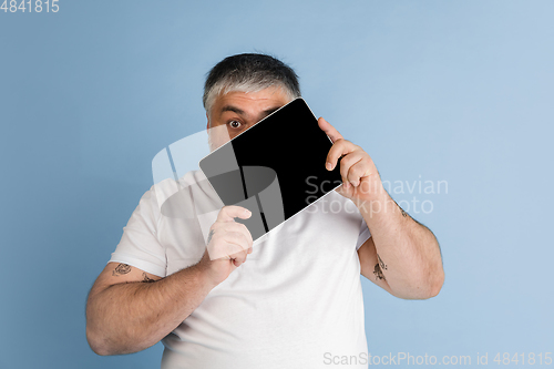 Image of Handsome caucasian plus size male model isolated on blue studio background. Concept of inclusion, human emotions, facial expression