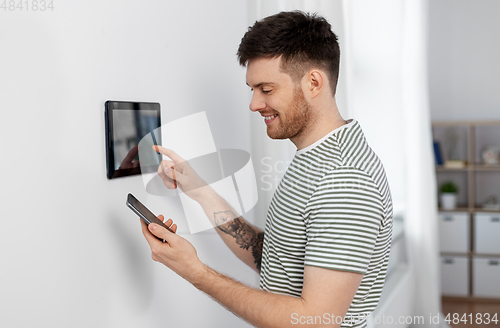 Image of smiling man using tablet computer at smart home