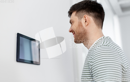 Image of happy man looking at tablet computer at smart home