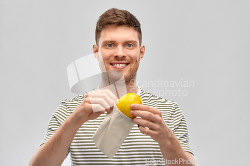 Image of smiling man with lemon in reusable canvas bag