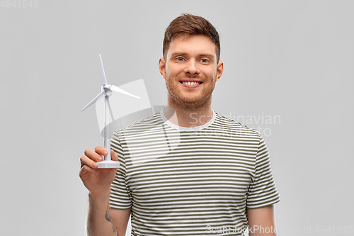 Image of smiling young man with toy wind turbine