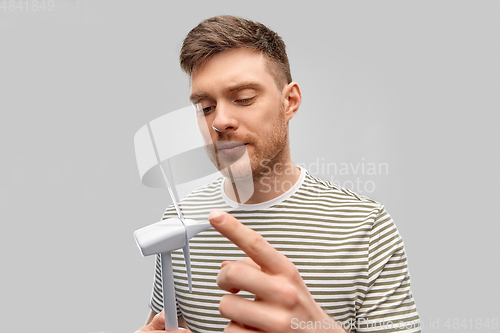 Image of young man with toy wind turbine