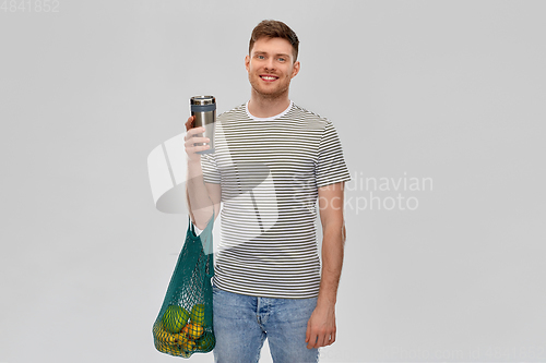 Image of man with food in bag and tumbler or thermo cup