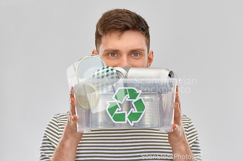 Image of smiling young man sorting metallic waste