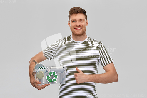 Image of smiling young man sorting metallic waste