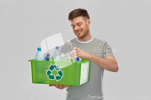 Image of smiling young man sorting plastic waste